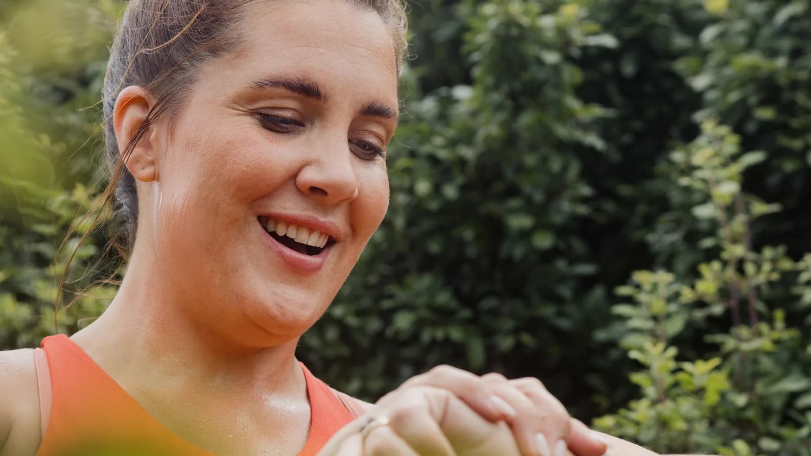 Kobieta w sportowym stroju na zewnątrz zerka na zegarek na nadgarstku